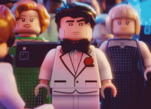 Animated video of a LEGO minifigure in a white tuxedo gasping in front of a small crowd.